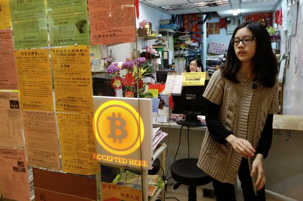 A staff member from a travel agency displays a Bitcoin logo as they accept bitcoins for payment in Hong Kong Friday, Feb. 28, 2014, after the world's first bitcoin retail store opened in Hong Kong, despite the virtual currency facing much scrutiny. A staff member from a travel agency displays a Bitcoin logo as they accept bitcoins for payment in Hong Kong Friday, Feb. 28, 2014, after the world's first bitcoin retail store opened in Hong Kong, despite the virtual currency facing much scrutiny. - Sputnik International