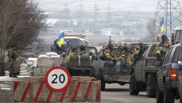Ukrainian government troops sit in the back of pick-up trucks as they pass a checkpoint near the town of Mariupol, Ukraine - Sputnik International