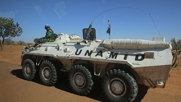 A member of the UN-African Union mission in Darfur (UNAMID) sits on an armoured personnel carrier patrolling near the city of Nyala in Sudan's Darfur - Sputnik International