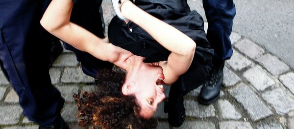 A Femen activist is taken away by police officers as she protests Tuesday, Feb. 10, 2015 in front of the Lille courthouse in Lille, northern France, where Dominique Strauss-Kahn goes on trial for sex charges in France. - Sputnik International