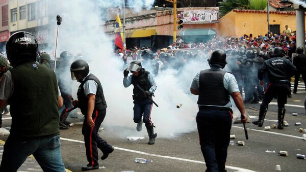 Police runs amidst tear gas as they clash with opposition students during a march against President Nicolas Maduro's government in San Cristobal February 12, 2015. - Sputnik International