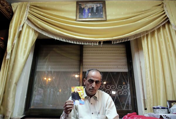 Said Musallam, whose son, Muhammad, is being held by Islamic State in Syria as an alleged spy, holds his photograph in his East Jerusalem home. Said Musallam, whose son, Muhammad, is being held by Islamic State in Syria as an alleged spy, holds his photograph in his East Jerusalem home. - Sputnik International