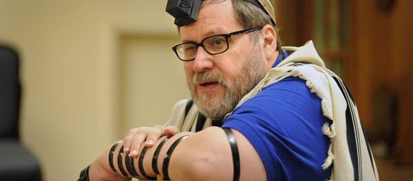 Rabbi Barry Freundel wears tefillin. Judaism teaches that the leather straps and boxes, which hold scriptural passages, are a way of connecting one’s heart, head and hand in prayer. - Sputnik International