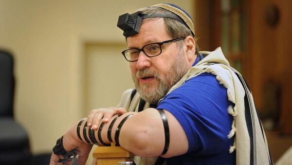 Rabbi Barry Freundel wears tefillin. Judaism teaches that the leather straps and boxes, which hold scriptural passages, are a way of connecting one’s heart, head and hand in prayer. - Sputnik International