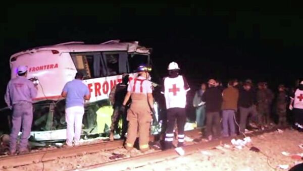 In this image made from Associated Press Television News video emergency responders work at the scene of a bus and freight train collision Friday Feb. 13, 2015. The collision at a grade crossing in northern Mexico, killed at least 16 people and injured 22, according to a Mexican official. The official said the accident Friday occured in the town of Anahuac, which is Tamaulipas state near the border city of Nuevo Laredo, across from Laredo, Texas. - Sputnik International