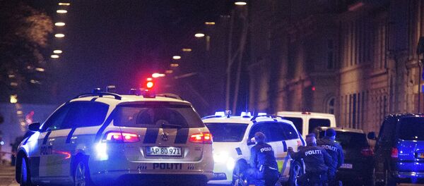 Police officers take cover behind their patrol cars on the streets of central Copenhagen on February 15, 2015 - Sputnik International