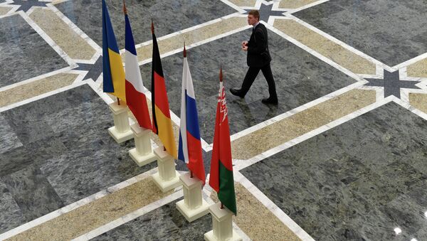 A man walks close to the flags on France, Russia, Germany, Ukraine and Belarus at the presidential residence in Minsk on February 11, 2015 - Sputnik International