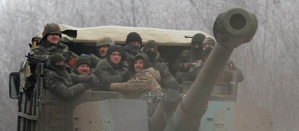 Ukrainian government soldiers ride on a vehicle on the road between the towns of Dabeltseve and Artemivsk, Ukraine, Saturday, Feb. 14, 2015 Ukrainian government soldiers ride on a vehicle on the road between the towns of Dabeltseve and Artemivsk, Ukraine, Saturday, Feb. 14, 2015 - Sputnik International