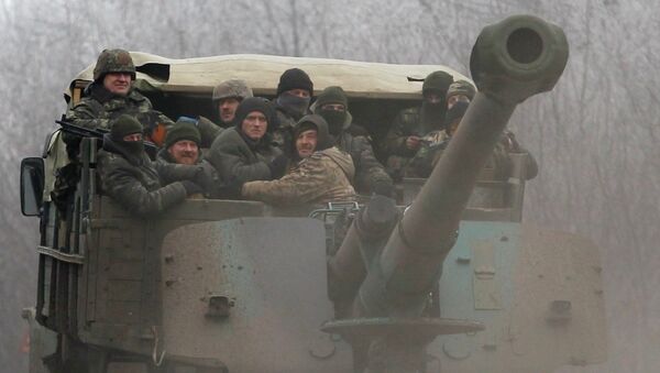 Ukrainian government soldiers ride on a vehicle on the road between the towns of Dabeltseve and Artemivsk, Ukraine, Saturday, Feb. 14, 2015 - Sputnik International