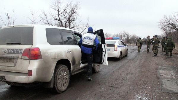 OSCE and police vehicles escort the bus column that arrived at Debaltsevo from the DPR for evacuation of local residents from the combat zone - Sputnik International