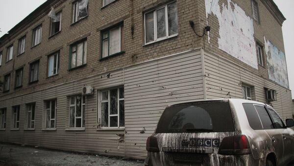 An OSCE vehicle near a house destroyed during bombardment in Debaltseve - Sputnik International