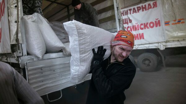 A man carries a sack of flour from a truck, that is part of a Russian humanitarian convoy delivering food, in Donetsk, February 15, 2015 - Sputnik International