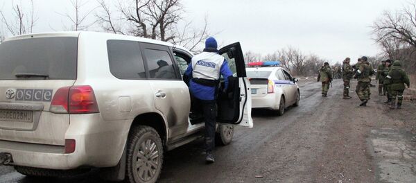 OSCE and police vehicles escort the bus column that arrived at Debaltsevo from the DPR for evacuation of local residents from the combat zone - Sputnik International