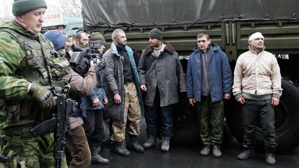 Prisoners of war (POWs), representing Ukrainian armed forces and escorted by members of the armed forces of the separatist self-proclaimed Donetsk People's Republic, line up as they visit a site near the public transport stop, where civilians were earlier killed on Thursday, in Donetsk, January 22, 2015. File photo. - Sputnik International