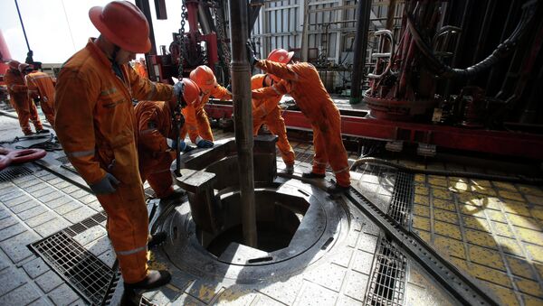 Oil workers lower the drill on the Centenario deep-water drilling platform off the coast of Veracruz, Mexico in the Gulf of Mexico, Friday, Nov. 22, 2013 - Sputnik International