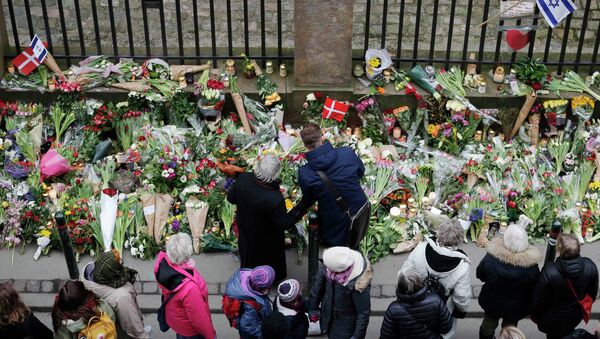 People pause for a moment of silence at a memorial site for the victims of the deadly attacks in front of the synagogue in Krystalgade in Copenhagen, February 16, 2015 - Sputnik International