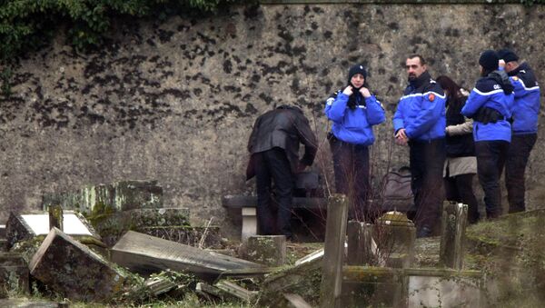 Police officers investigate the site of defaced tombstones at the Jewish cemetery of Sarre-Union, eastern France, Monday, Feb. 16, 2015 - Sputnik International