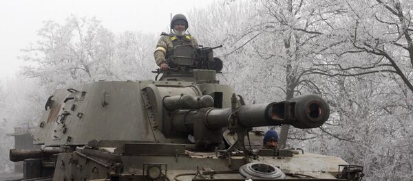 Ukrainian servicemen patrol with a self-propelled artillery gun on the road between Artemivsk and Debaltseve, in the region of Donetsk, on February 15, 2015 Ukrainian servicemen patrol with a self-propelled artillery gun on the road between Artemivsk and Debaltseve, in the region of Donetsk, on February 15, 2015 - Sputnik International