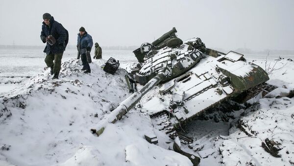 Members of the self-proclaimed Donetsk People's Republic army collect parts of a destroyed Ukrainian army tank in the town of Vuhlehirsk, about 10 km (6 miles) to the west of Debaltseve, February 16, 2015 - Sputnik International