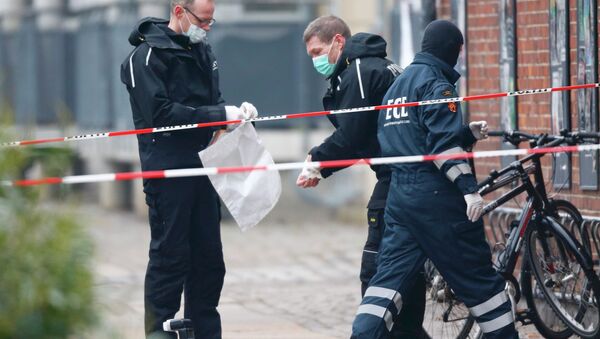 Danish police investigate the area where an unattended package was found in front of a cafe in Oesterbro, Copenhagen February 17, 2015 - Sputnik International