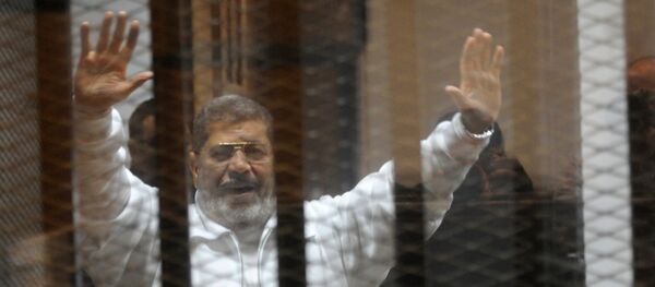Egypt's deposed Islamist president Mohamed Morsi waves from inside the defendant’s cage during his trial at the police academy in Cairo. Egypt's deposed Islamist president Mohamed Morsi waves from inside the defendant’s cage during his trial at the police academy in Cairo. - Sputnik International