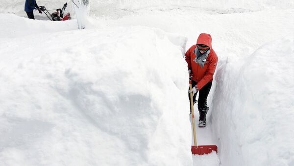Kim Taylor, of Norwood, Mass., right, shovels a path in the snow in front of her home Sunday, Feb. 15, 2015, in Norwood. A storm brought a new round of wind-whipped snow to New England on Sunday, threatening white-out conditions in coastal areas and forcing people to contend with a fourth winter onslaught in less than a month. - Sputnik International