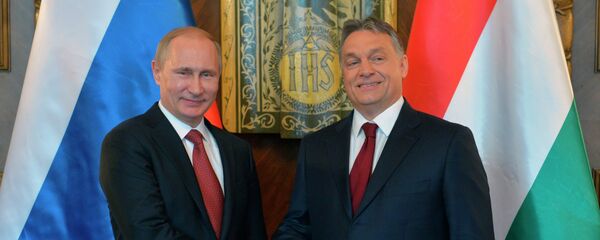 Russian President Vladimir Putin, left, and Hungarian Prime Minister Viktor Orban shake hands during their meeting at the parliament building in Budapest - Sputnik International