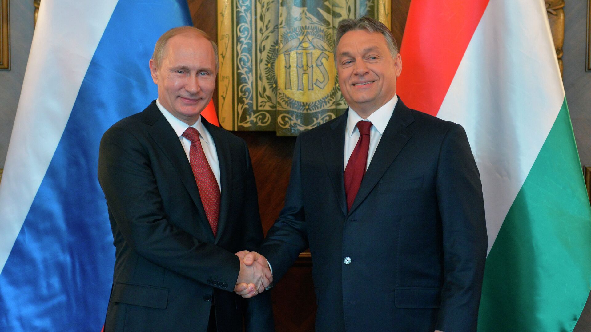Russian President Vladimir Putin, left, and Hungarian Prime Minister Viktor Orban shake hands during their meeting at the parliament building in Budapest - Sputnik International, 1920, 01.02.2022