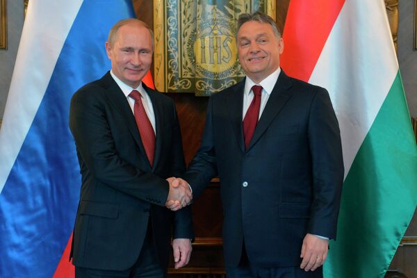 Russian President Vladimir Putin, left, and Hungarian Prime Minister Viktor Orban shake hands during their meeting at the parliament building in Budapest - Sputnik International