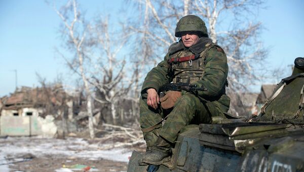 Independence supporter of self-proclaimed Donetsk People's Republic army sits on top of an armoured personnel carrier in the village of Nikishine, south east of Debaltseve February 17, 2015 - Sputnik International