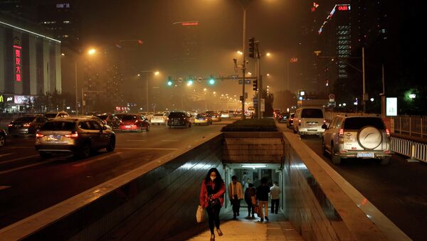 A woman wearing a mask to protect herself from pollutants walks out from an underground tunnel against a backdrop of the city skylines shrouded by haze in Beijing, China Monday, Oct. 20, 2014 - Sputnik International