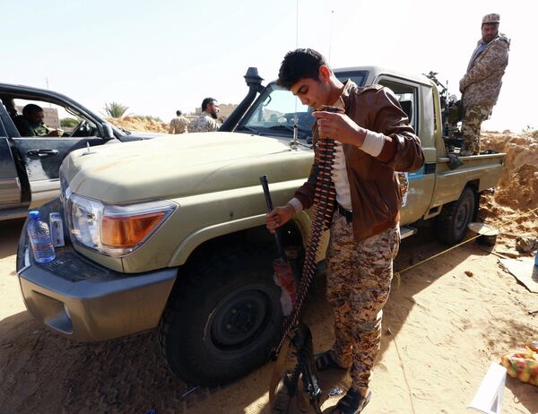Fighters from the Fajr Libya (Libya Dawn) militia hold a position during clashes with forces loyal to Libya's internationally recognised government as they fight for the control of the area near the Wetia military air base on February 4, 2015 in al-Aqrabiyah, some 170 kilometres west of the capital Tripoli Fighters from the Fajr Libya (Libya Dawn) militia hold a position during clashes with forces loyal to Libya's internationally recognised government as they fight for the control of the area near the Wetia military air base on February 4, 2015 in al-Aqrabiyah, some 170 kilometres west of the capital Tripoli - Sputnik International
