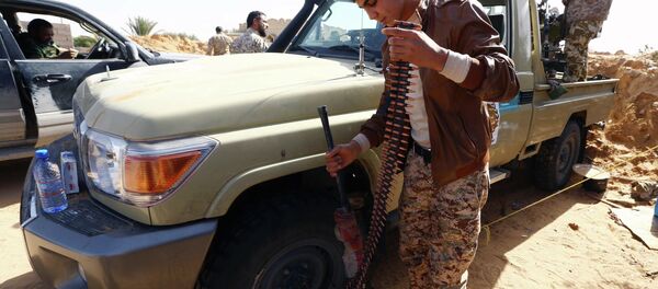 Fighters from the Fajr Libya (Libya Dawn) militia hold a position during clashes with forces loyal to Libya's internationally recognised government as they fight for the control of the area near the Wetia military air base on February 4, 2015 in al-Aqrabiyah, some 170 kilometres west of the capital Tripoli - Sputnik International