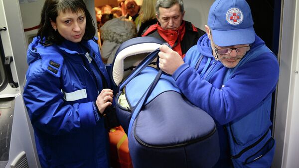 Medics carry a container with a critically ill child delivered to Moscow from Donbas - Sputnik International