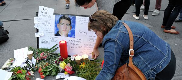 People places flowers and cards next to the portriat of Iranian asylum seeker Reza Berati during a candlelight vigil in support of asylum seekers, in Melbourne on February 23, 2014 - Sputnik International