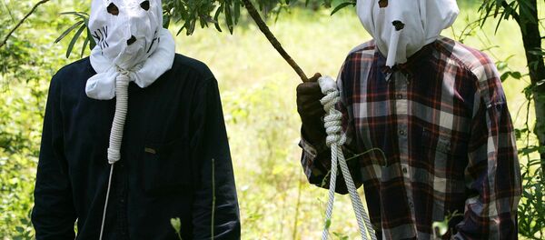 Ben Reed, right, and Keith Christian, left, portraying Klansmen, run through a reenactment of the 1946 lynching at the Moore's Ford Bridge, to raise awareness for the unsolved murders. - Sputnik International