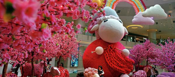 A girl touches a goat decoration as a shopping mall floor is decorated with goat installation to celebrate the upcoming Chinese Lunar New Year in Hong Kong - Sputnik International
