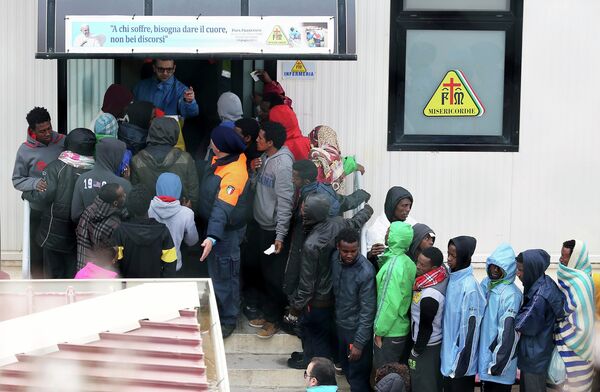 Migrants stand in front of the infirmary at the immigration center on the southern Italian island of Lampedusa February 19, 2015. Migrants stand in front of the infirmary at the immigration center on the southern Italian island of Lampedusa February 19, 2015. - Sputnik International