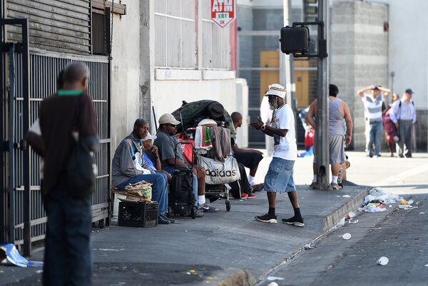 Men sit along a street in Skid Row in Los Angeles, California - Sputnik International