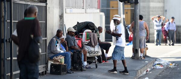 Men sit along a street in Skid Row in Los Angeles, California Men sit along a street in Skid Row in Los Angeles, California - Sputnik International
