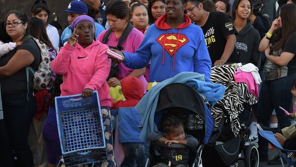 Mothers and their children wait for new shoes and school supplies during a charity event in Los Angeles - Sputnik International