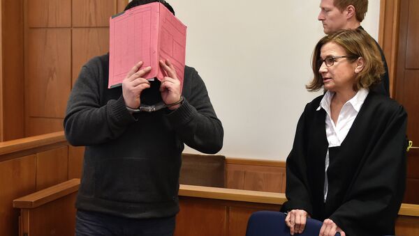 The former nurse identified only as Niels H. hides his face behind a folder while arriving in the courtroom beside his lawyer, Ulrike Baumann, in Oldenburg, Germany. - Sputnik International