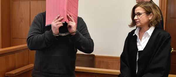 The former nurse identified only as Niels H. hides his face behind a folder while arriving in the courtroom beside his lawyer, Ulrike Baumann, in Oldenburg, Germany. The former nurse identified only as Niels H. hides his face behind a folder while arriving in the courtroom beside his lawyer, Ulrike Baumann, in Oldenburg, Germany. - Sputnik International