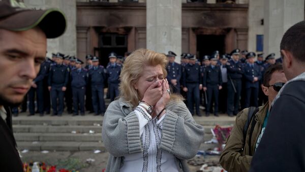 A woman cries back dropped by police troops guarding the burnt trade union building in Odessa, Ukraine, Saturday, May 3, 2014, where more than 30 people died trying to escape during clashes the day before - Sputnik International