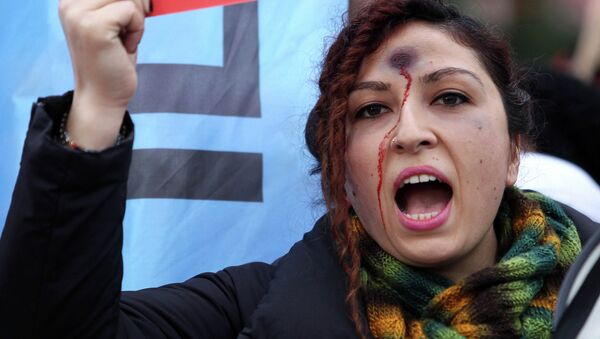 A woman with a bullet hole painted on her forehead takes part in a demonstration against the murder of 20-year-old Ozgecan Aslan. - Sputnik International
