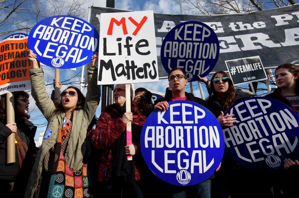 Abortion rights advocates hold signs while anti-abortion demonstrators walk by during the annual March for Life in Washington, DC. Abortion rights advocates hold signs while anti-abortion demonstrators walk by during the annual March for Life in Washington, DC. - Sputnik International