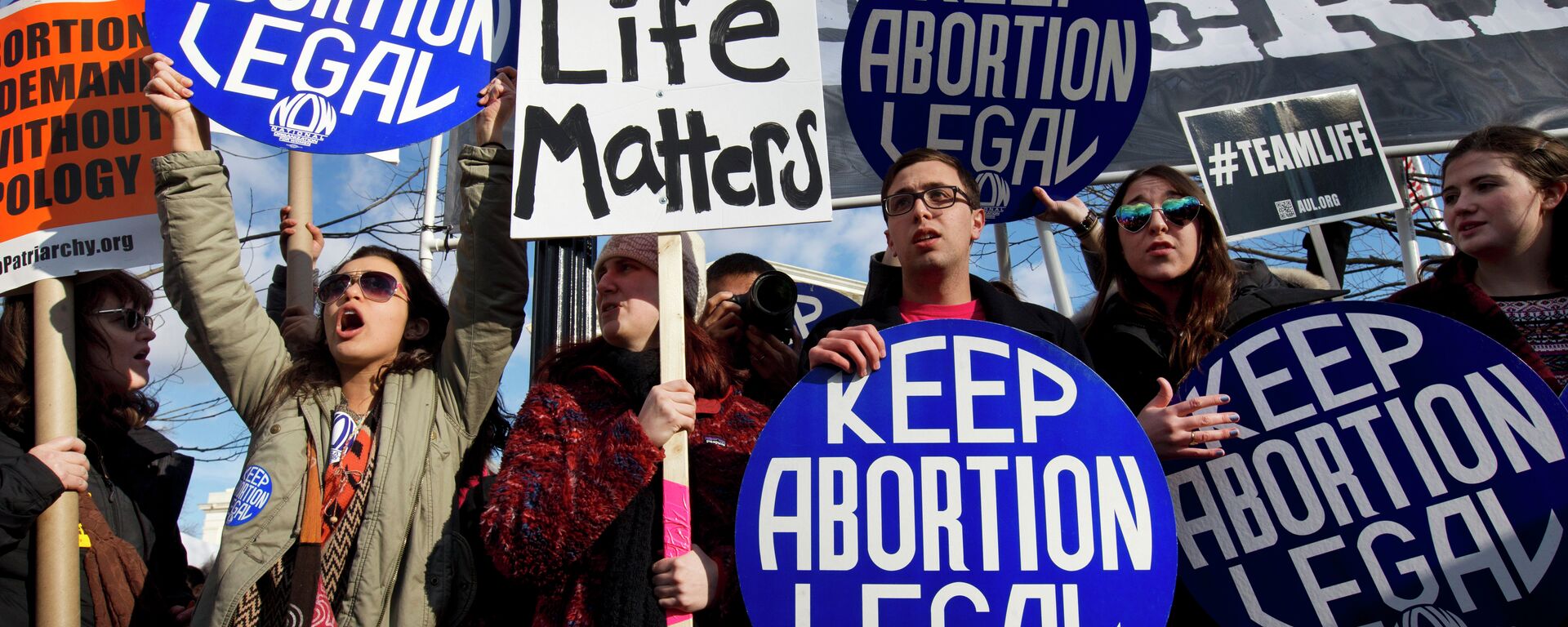 Abortion rights advocates hold signs while anti-abortion demonstrators walk by during the annual March for Life in Washington, DC. - Sputnik International, 1920, 23.09.2021