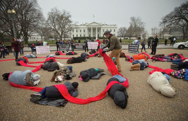 Anti-abortion activists are connected with a red piece of cloth as they stage a die-in in front of the White House. Anti-abortion activists are connected with a red piece of cloth as they stage a die-in in front of the White House. - Sputnik International