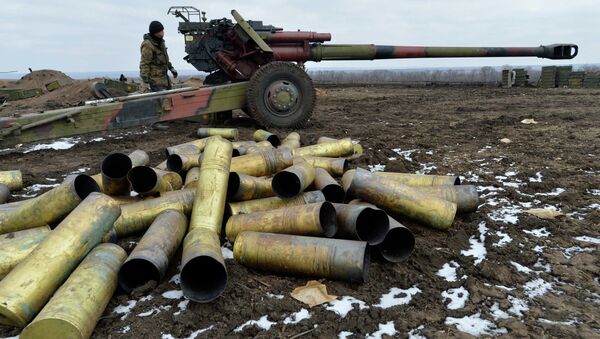 A member of the Ukrainian armed forces stands near a cannon, with shell cases seen in the foreground, at positions in Donetsk region, eastern Ukraine - Sputnik International
