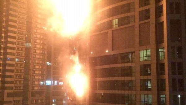 This photo provided by Rhea Saran shows flames coming from a high rise tower in Dubai's marina district Saturday, Feb. 21, 2015. - Sputnik International